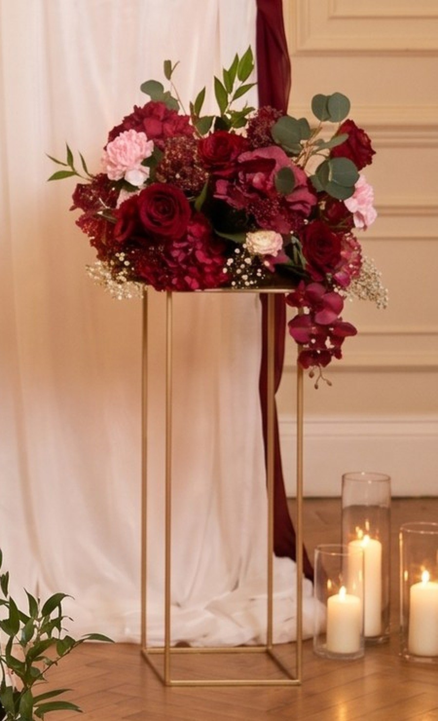 Red rose arrangement on a tall gold geometric stand